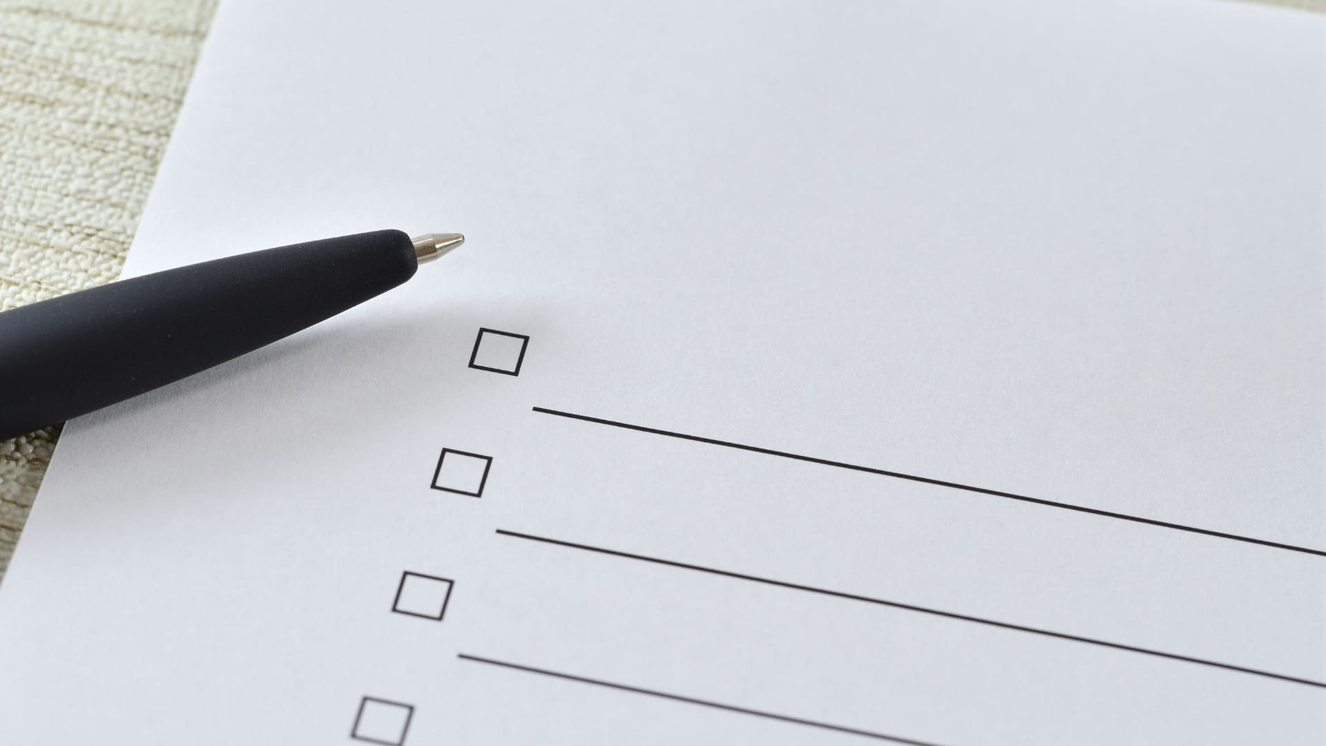 Eine Nahaufnahme einer Checkliste, die noch mit einem daneben liegenden Stift ausgefüllt werden muss