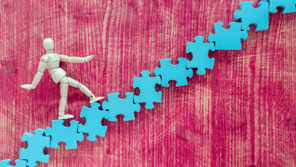 Eine Treppe aus Puzzlestücken, die bewältigt wird.